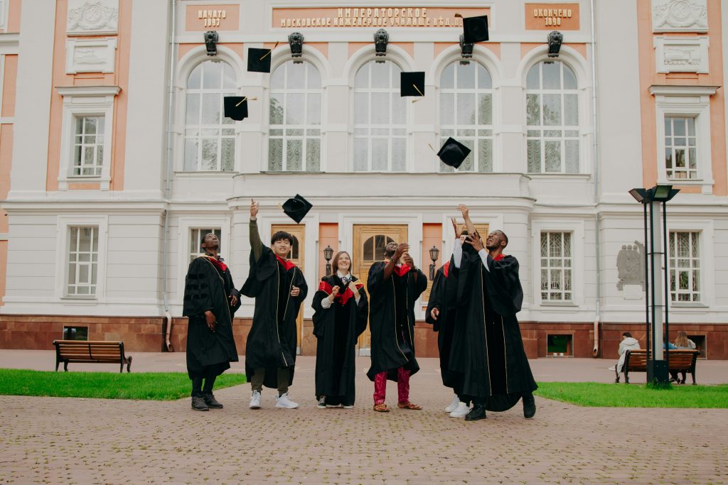 "The young immigrant generation celebrating graduation in front of a historic university building, symbolizing academic success and integration."